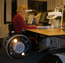 Chantal van Birgelen aan het werk, zittend aan haar aangepaste werkplek
