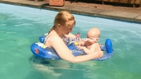 Anneke met haar zoontje en allebei in een zwemband dobberend op het water